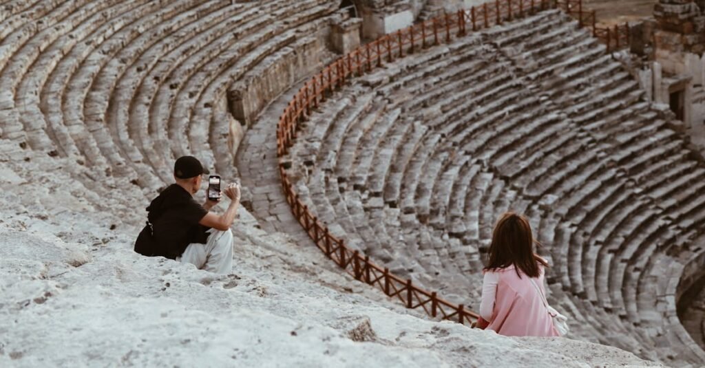 Visitors photograph an ancient amphitheater in Denizli, Türkiye. Stunning historical site exploration.