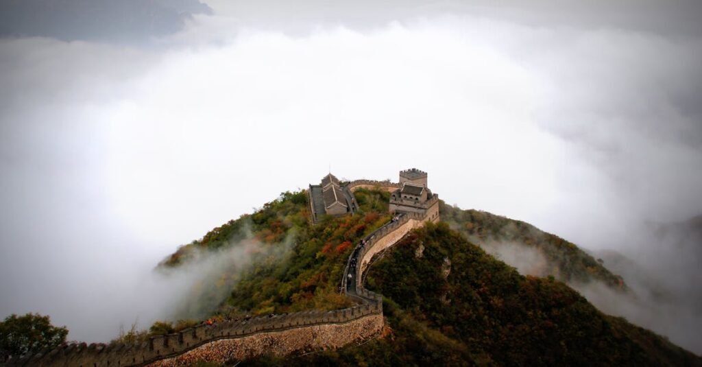 Majestic aerial shot of the Great Wall of China surrounded by mist and mountains.