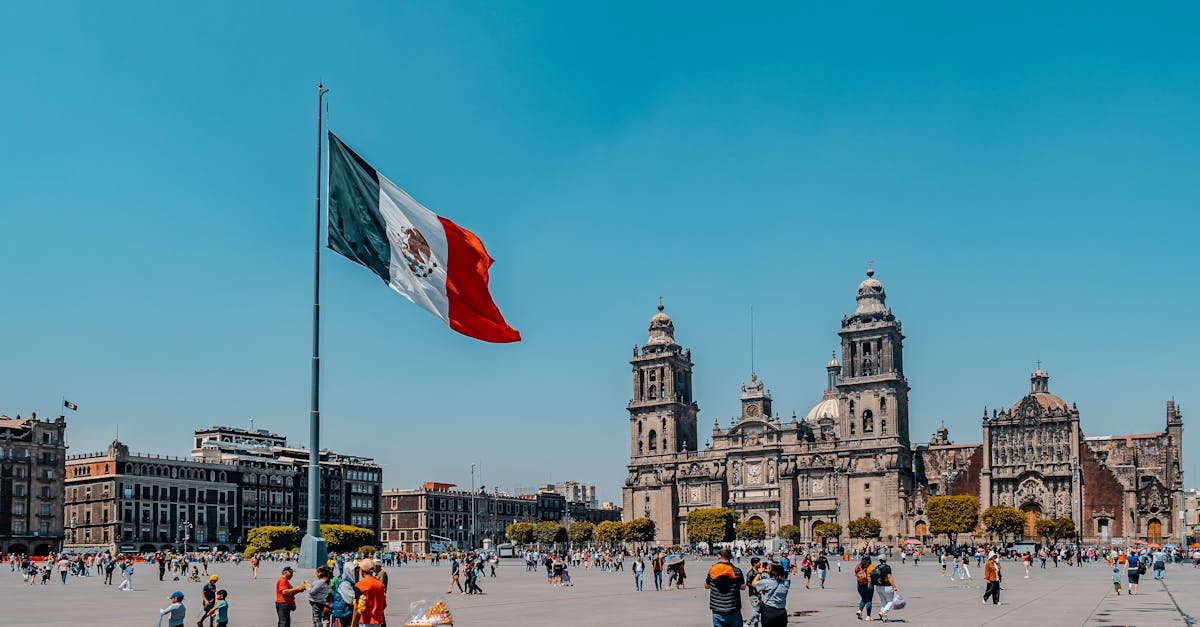 Vibrant view of Mexico City's Metropolitan Cathedral and Plaza de la Constitución under a clear blue sky.