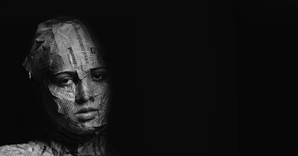 Intriguing portrait of a person covered in newspaper, captured in dramatic black and white.