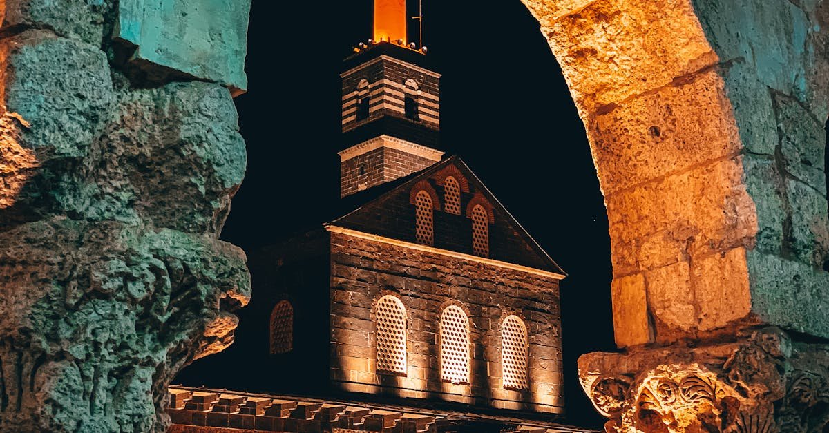 Stunning nighttime capture of the historic Diyarbakır Grand Mosque through ancient stone arches in Türkiye.
