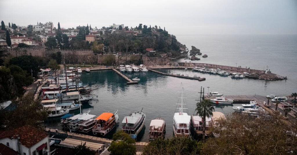Aerial view of Antalya Harbor with boats docked and the Mediterranean Sea in the background.