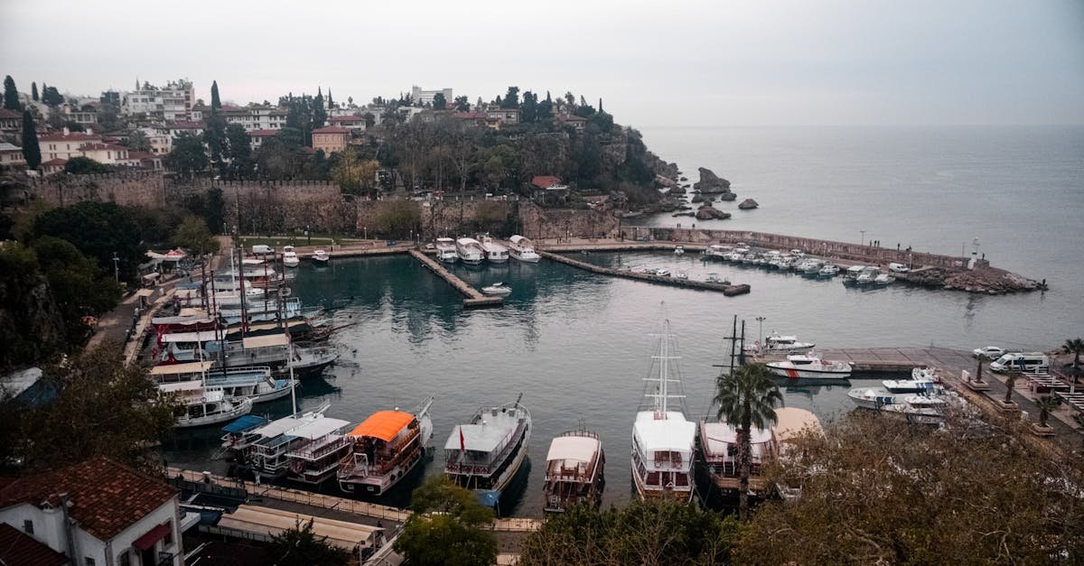 Aerial view of Antalya Harbor with boats docked and the Mediterranean Sea in the background.