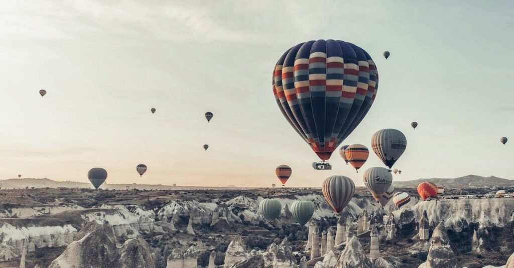 Multicolored hot air balloons flying above famous vast rocky valley in Cappadocia Turkey on early morning on fair weather