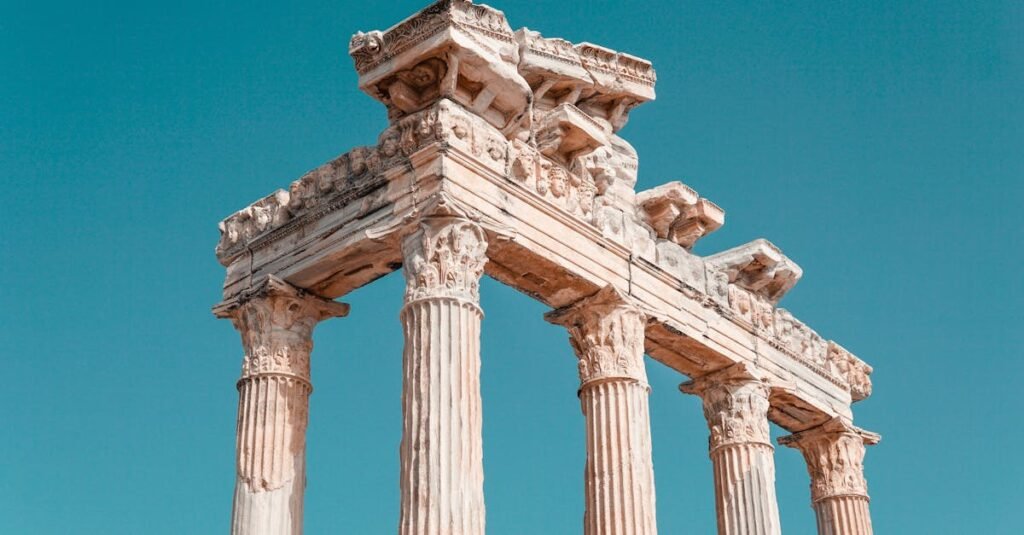 View of the historic columns of the Temple of Apollo under a clear blue sky in Antalya.