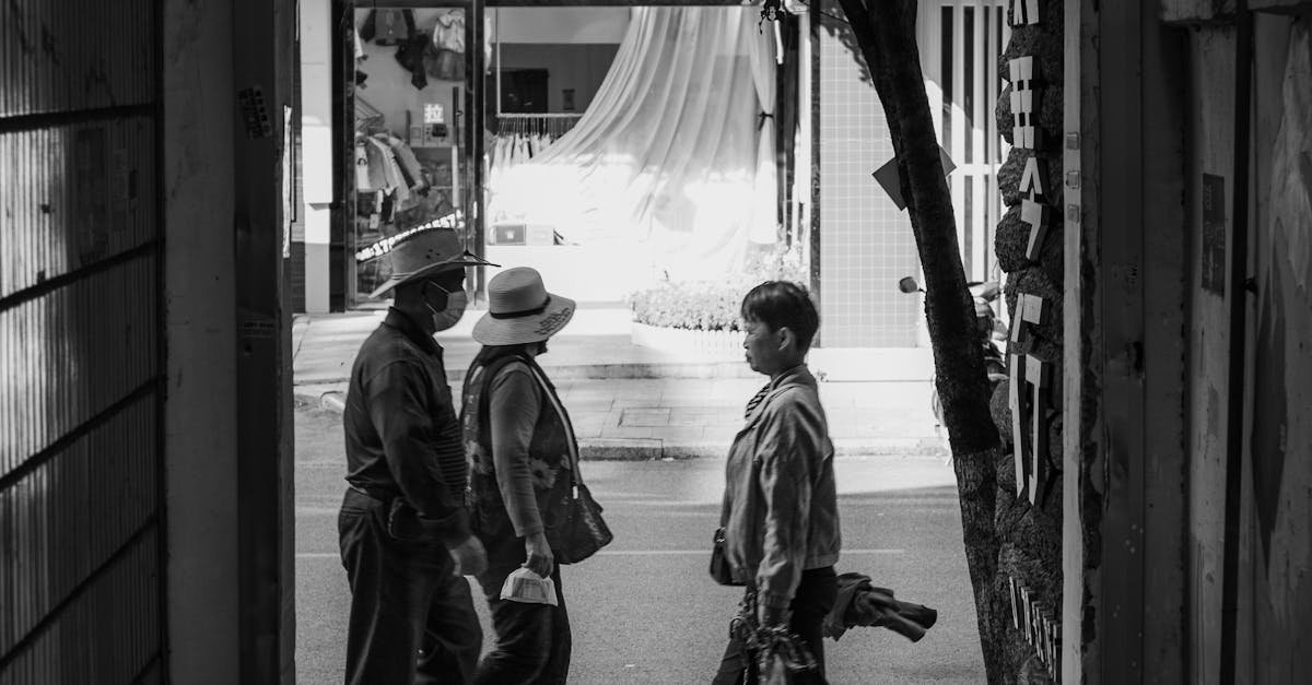 Monochrome image of pedestrians walking through a city gateway, capturing a candid urban moment.
