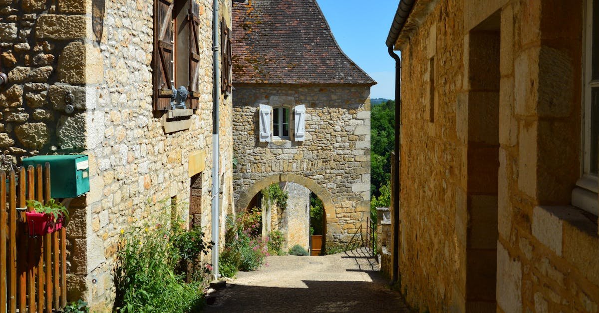 Quaint alley in a picturesque village with historic stone houses and cobblestone path.