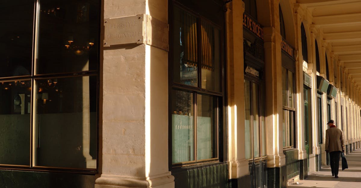 Sunlit corridor of Paris' Palais Royal highlighting classic architecture.