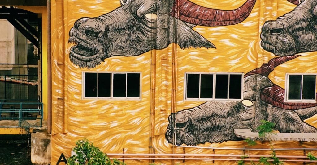 Colorful street art depicting bulls on an urban building facade.