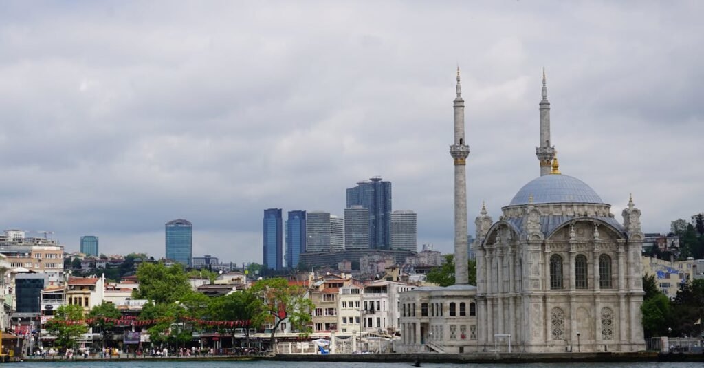 Scenic view of Ortaköy Mosque with Istanbul skyline backdrop under cloudy skies.