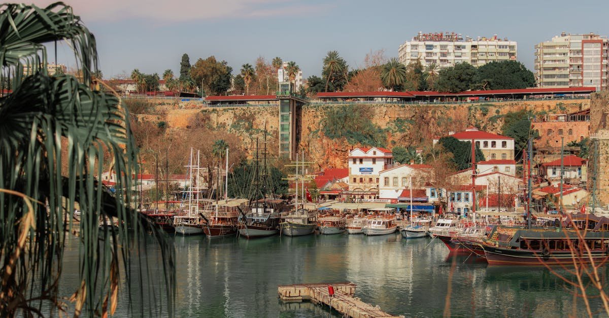 Beautiful view of Antalya's marina with boats, harbor, and cityscape in sunny weather.