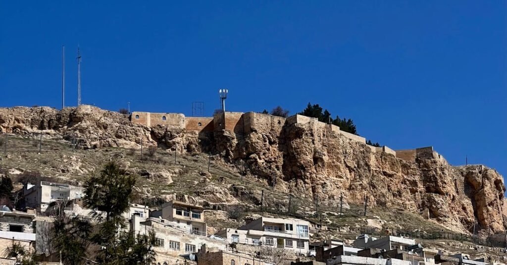 Explore the timeless charm of Mardin's historic architecture set against a vibrant blue sky.