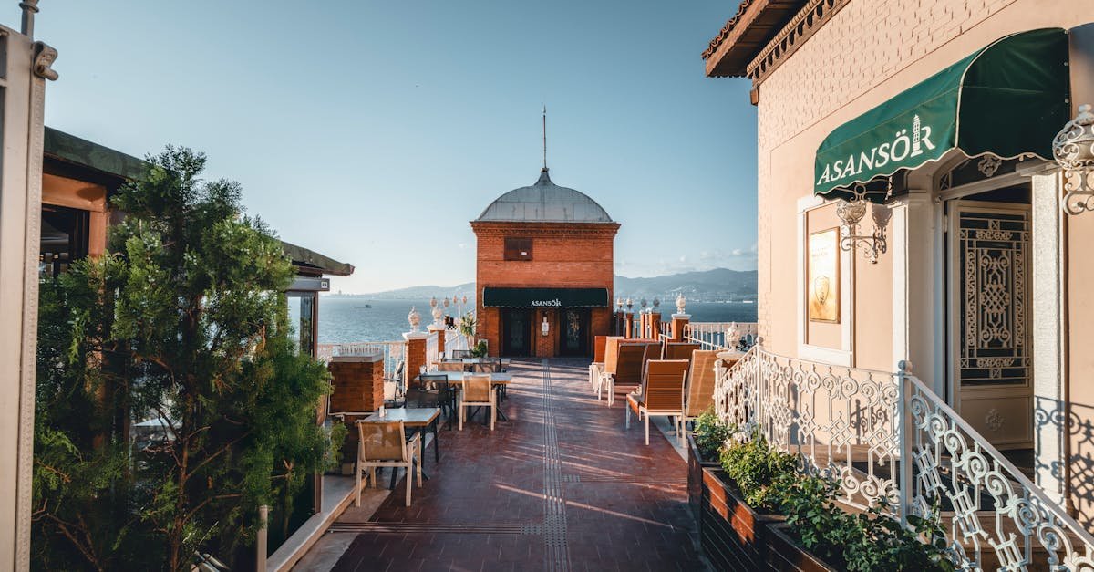 Explore the charming walkway and iconic Asansör Tower in İzmir, Türkiye, under clear skies.