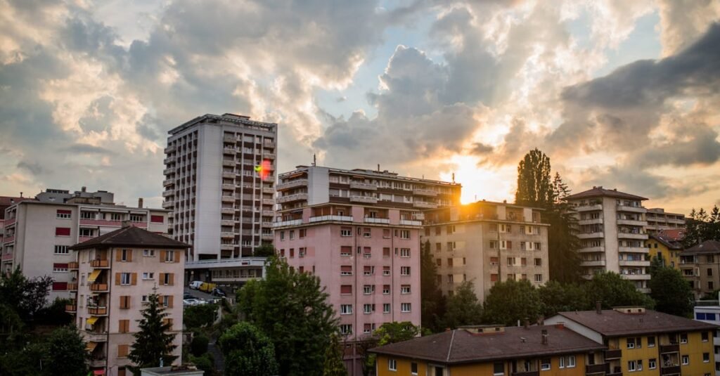 Panoramic view of cityscape with high-rise apartment buildings during sunset under dramatic clouds.