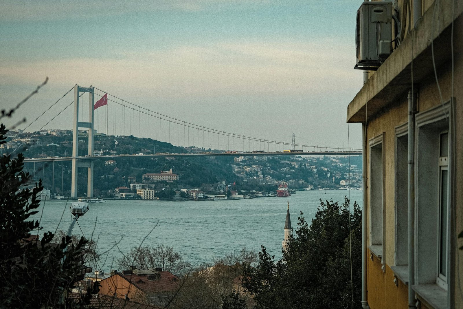 A scenic view of İstanbul's Bosphorus Bridge with surrounding architecture on a clear day.