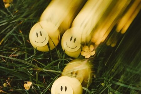 Yellow smiley balls rolling on green grass