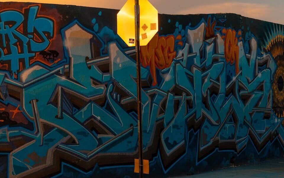 Graffiti wall and street sign at sunset