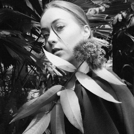 Young woman with plant leaves around her neck