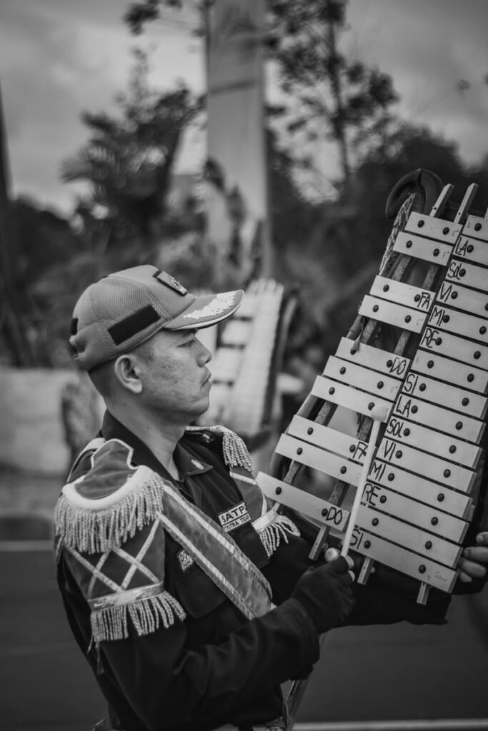 Black and white image of a musician playing a xylophone outdoors.