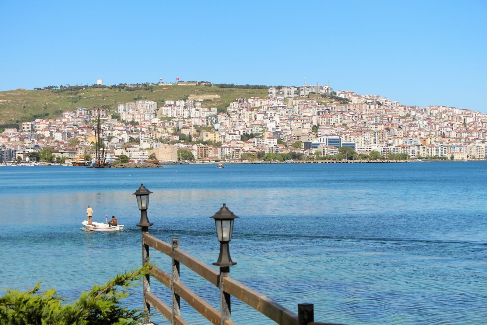 Explore the beautiful waterfront and cityscape of Sinop, Türkiye, with serene water and lush hills.