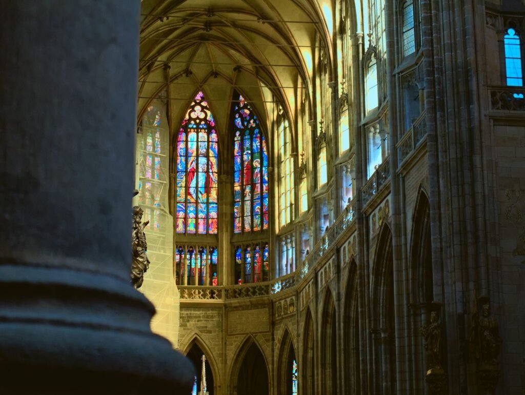 Intricate stained glass and gothic architecture inside Prague's St. Vitus Cathedral.