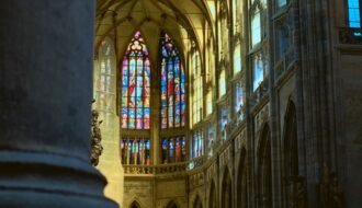 Intricate stained glass and gothic architecture inside Prague's St. Vitus Cathedral.