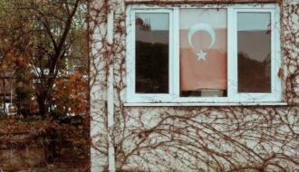 A charming old house in Tekirdağ, Türkiye, showcasing a Turkish flag and ivy-covered walls.