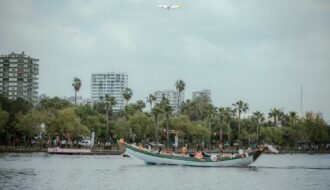 A picturesque view of a boat on the river, with buildings and an airplane in Adana, Türkiye.