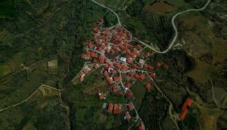 A stunning aerial view of a rural village with red-roofed houses at sunset.