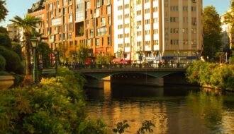 Charming urban riverside view in Eskişehir with lush greenery and modern architecture.