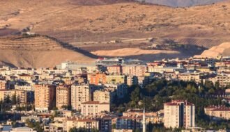Aerial view of Siirt city surrounded by mountains in Türkiye, capturing its urban and natural elements.