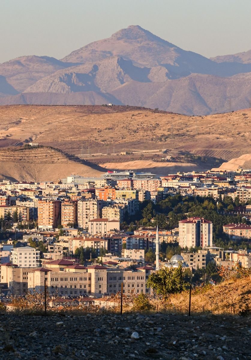 Aerial view of Siirt city surrounded by mountains in Türkiye, capturing its urban and natural elements.