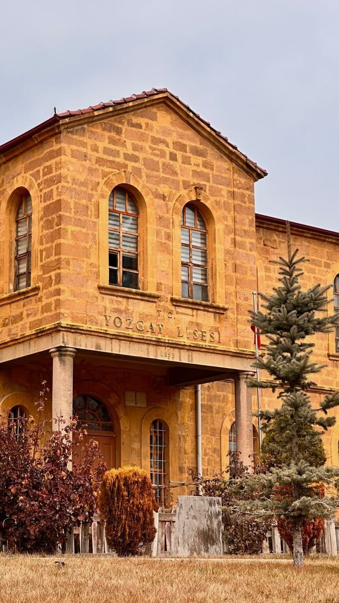 A historic educational building with autumn foliage, Yozgat Lisesi stands in Yozgat, Türkiye.