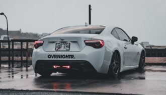 A white sports car parked on a wet parking lot