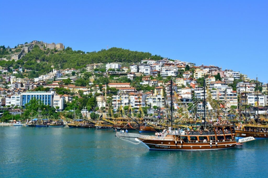 brown boat on body of water near city buildings during daytime