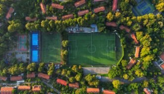 an aerial view of a soccer field surrounded by trees