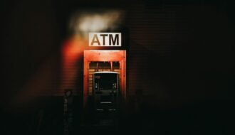 a building with a atm sign lit up at night