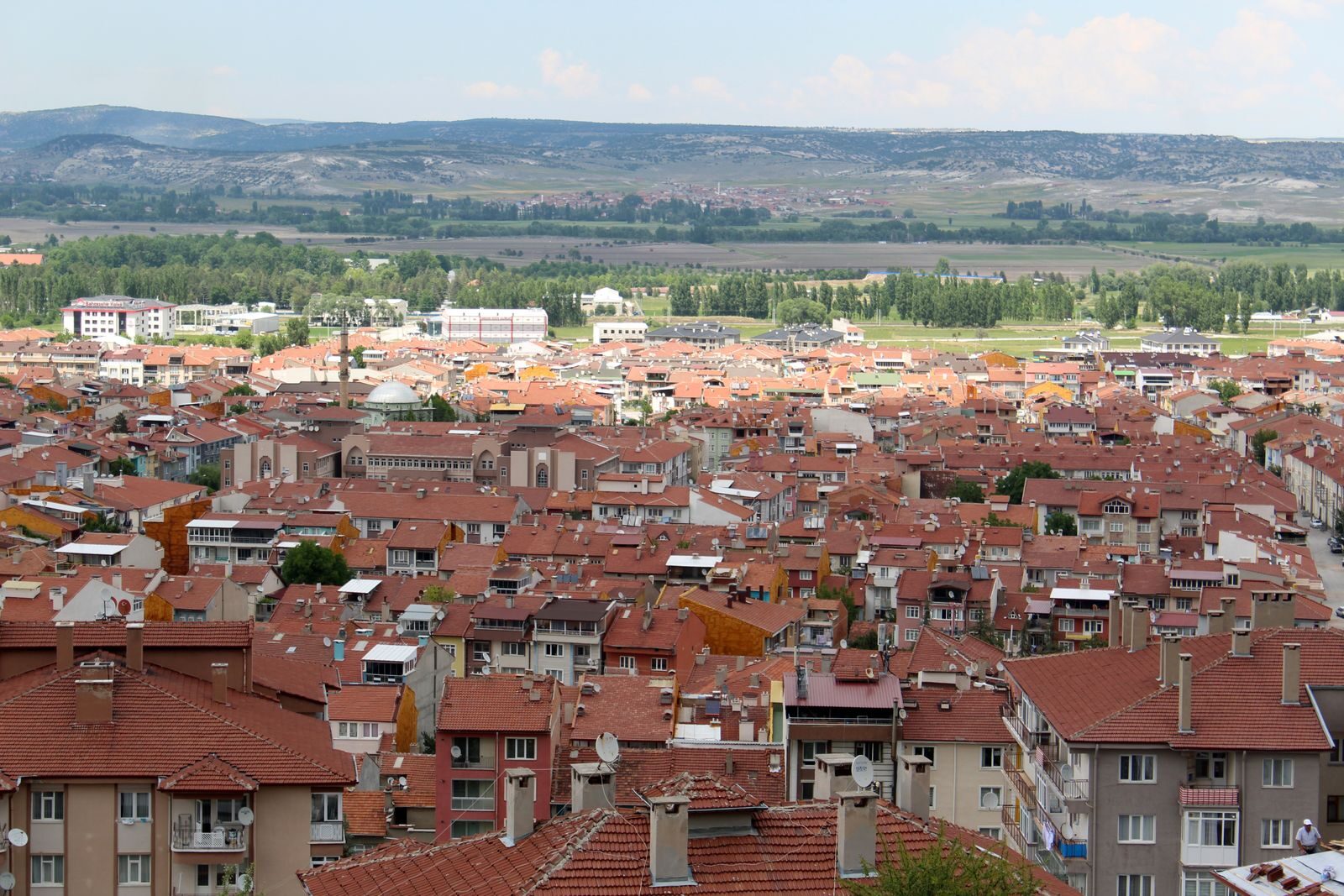 Explore the expansive cityscape of Kütahya, Türkiye, featuring terracotta rooftops and lush landscapes.