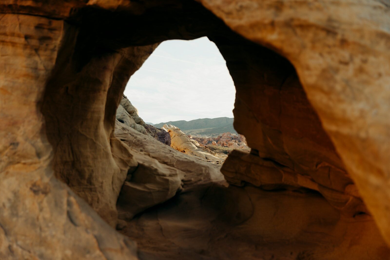 View through a rock arch at a desert landscape