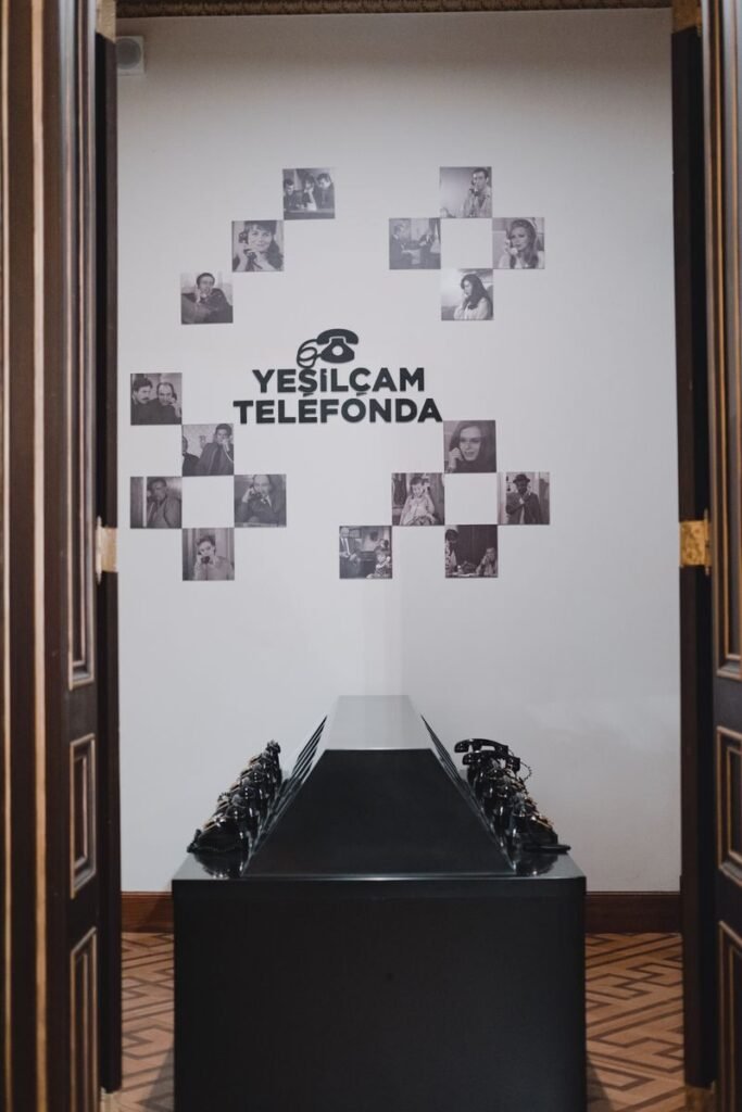 A nostalgic display of vintage telephones at the Yeşilçam Telefonda exhibit indoors.