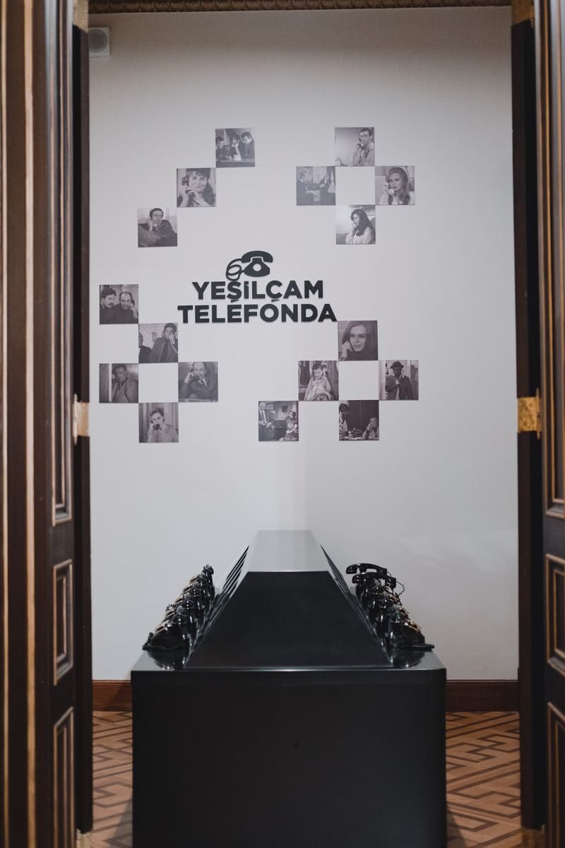 A nostalgic display of vintage telephones at the Yeşilçam Telefonda exhibit indoors.