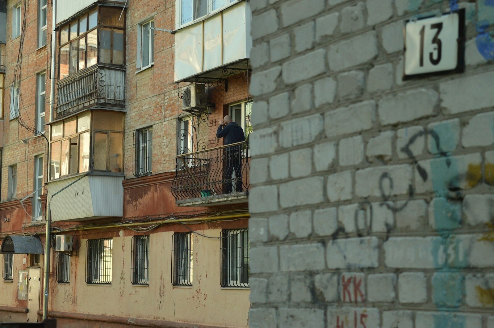 a man standing on a balcony next to a building