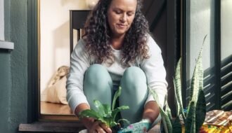 Woman potting a plant on a porch