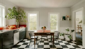 Bright kitchen with checkered floor, dining table, and large windows.