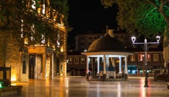 Illuminated night view of a plaza in Balıkesir, Türkiye, showcasing elegant architecture and peaceful ambiance.