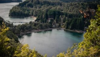 Stunning aerial view of Lake Nahuel Huapi surrounded by lush greenery in Villa La Angostura, Argentina.