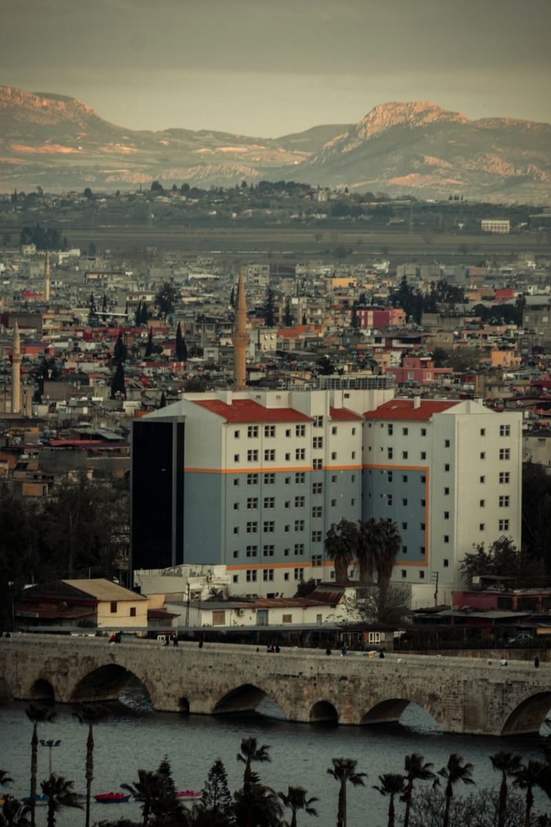 Aerial view of Adana, Türkiye showcasing the cityscape with mountains in the background.
