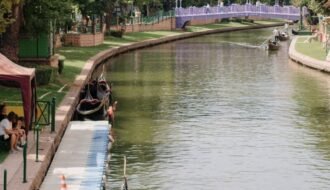 Idyllic canal view with gondolas and a purple bridge in Eskişehir, Turkey.