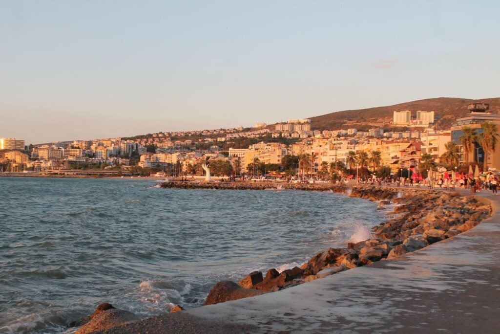 A stunning view of Kuşadası's coastline and cityscape during sunset.