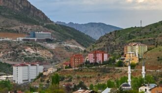 Picturesque landscape of Gümüşhane, Türkiye with colorful buildings and dramatic sky.